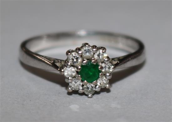 A 18ct white gold emerald and diamond cluster ring, size L